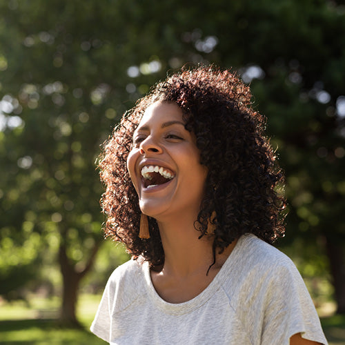 Smiling woman standing outside wearing a white shirt.